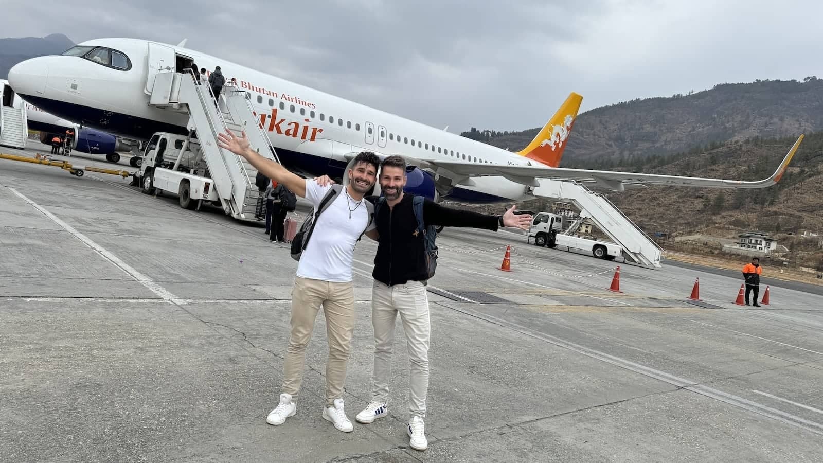 Drukair plane with gay couple posing at Paro International Airport.