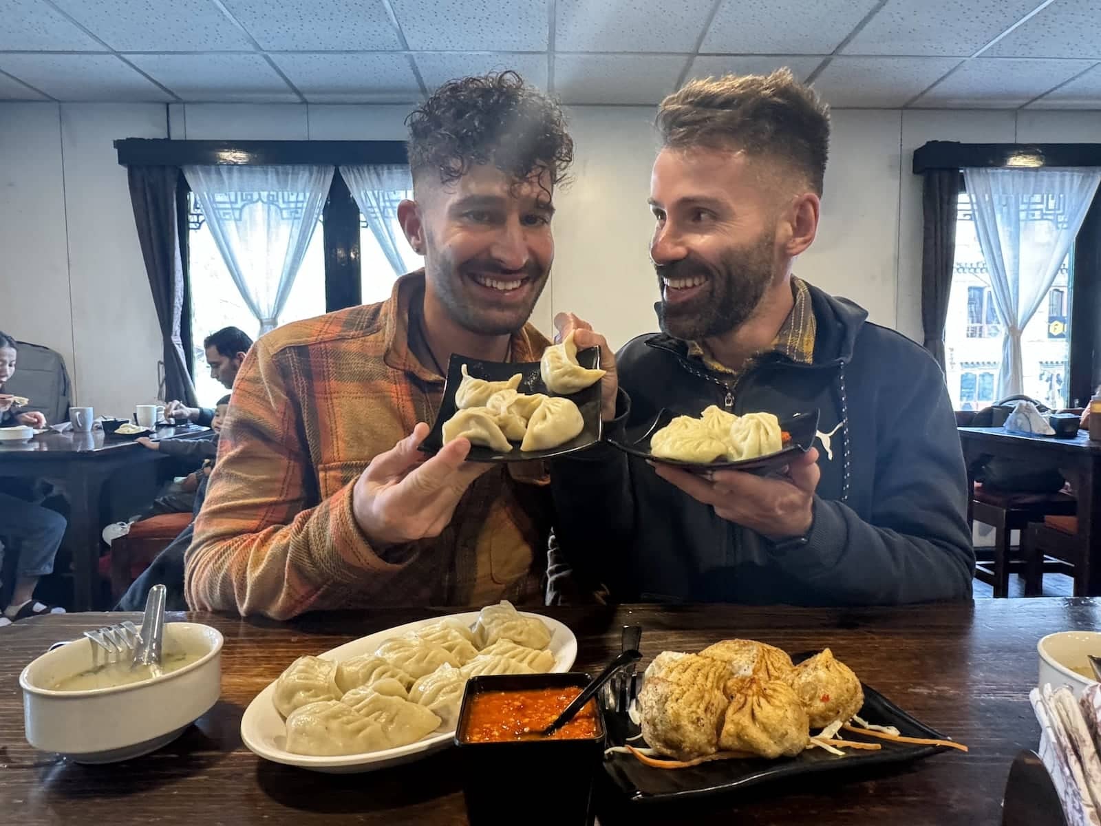 Gay couple eating momo dumplings at the Zombala Restaurant in Thimphu in Bhutan.